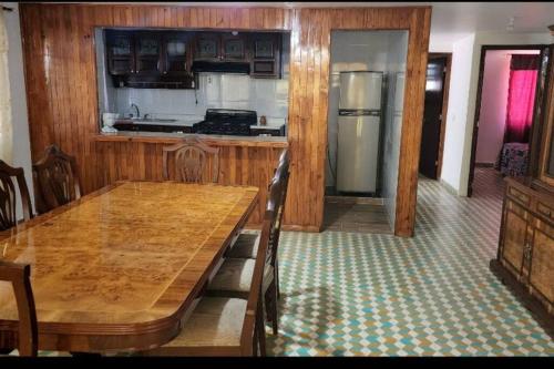 a kitchen with a wooden table and a refrigerator at Casa el Nogalito in Tasquillo