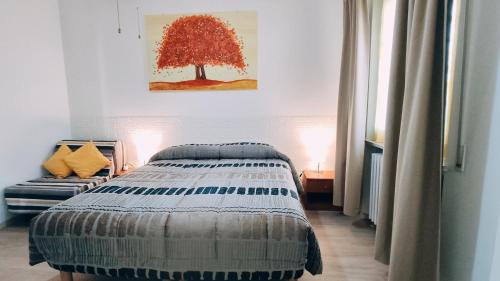 a bedroom with a bed and a tree on the wall at Casa Elvezia Guest House in SantʼElpidio a Mare
