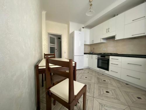a kitchen with white cabinets and a table and chairs at Новобуд.Стрийська,Ашан,Сихів,Автовокзал in Lviv