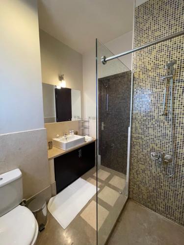 a bathroom with a shower and a toilet and a sink at Azzurra two-Bedroom Apartment at Sahl Hasheesh in Hurghada