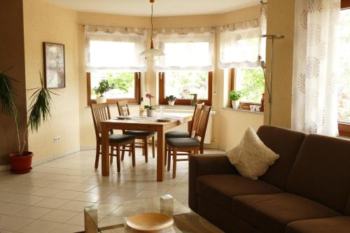 a living room with a couch and a table and chairs at Ferienwohnung Basche in Oberzissen