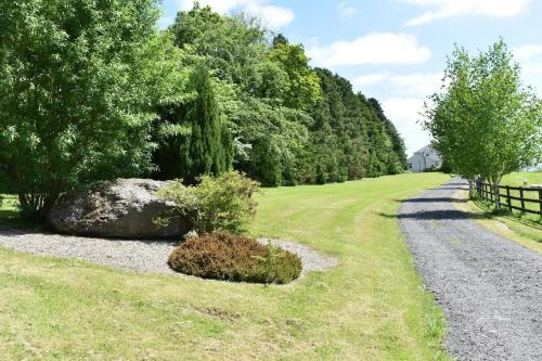 a gravel road with a rock and a fence at Lackandarralodge large 5BR entire house sleeps14! in Dungarvan