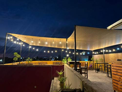 a patio with tables and chairs under a tent at night at Maison Verte - Budget Edition in Arequipa