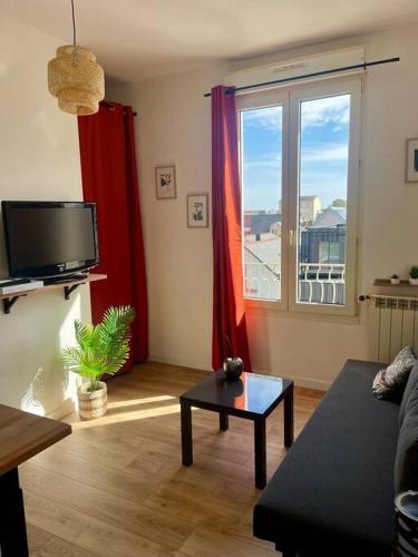 un salon avec un canapé et une télévision dans l'établissement L’Escale Rennaise, à Rennes