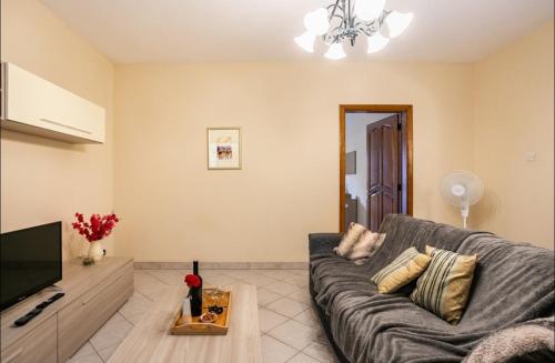 a living room with a couch and a tv at Aurora Apartment in Żurrieq