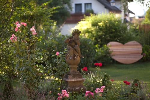 a statue of a woman sitting on a pedestal in a garden at Garten - Hotel Sallerhof in Salzburg