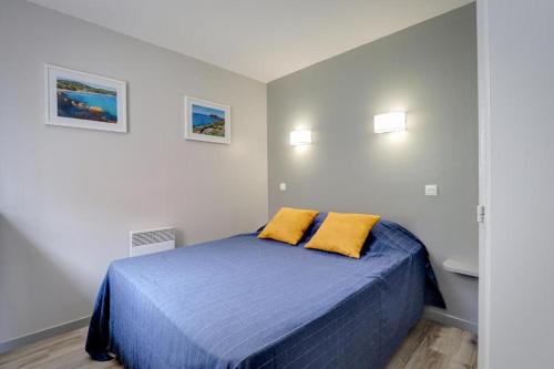 - une chambre avec un lit bleu et 2 oreillers jaunes dans l'établissement Grimaud, les Restanques, appartement vue mer, 4 personnes, à Grimaud