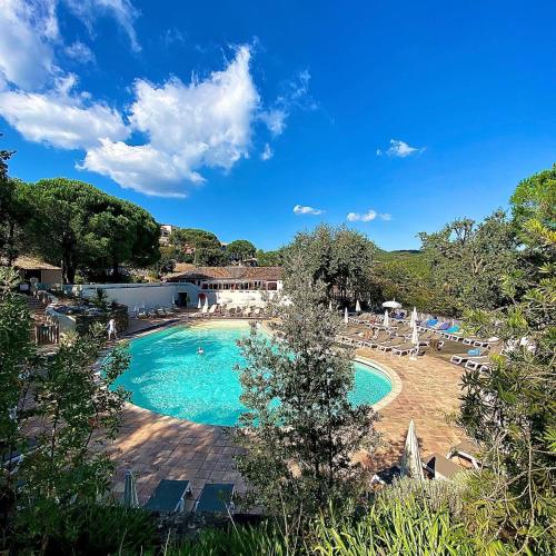 - une piscine avec des chaises et un complexe dans l'établissement Grimaud, les Restanques, appartement vue mer, 4 personnes, à Grimaud
