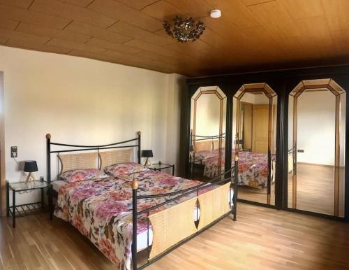 a bedroom with a bed and two mirrors at Urlaub im Grünen - Ferienwohnung EG im Brunnenhof in Reichshof 