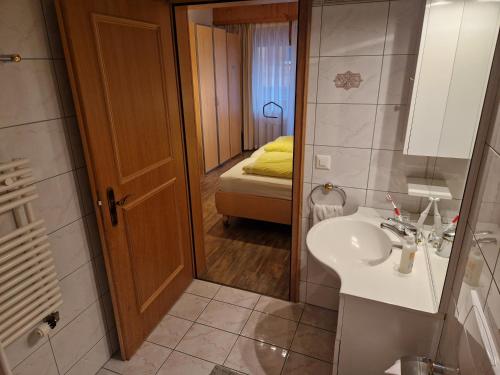 ein Badezimmer mit einem Waschbecken und ein Schlafzimmer mit einem Bett in der Unterkunft Residenz Darianne 12 in Leukerbad