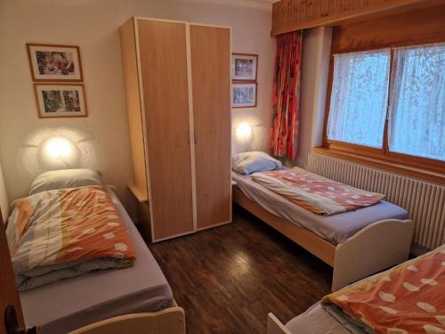 a small room with two beds and a cabinet at Residenz Darianne 12 in Leukerbad