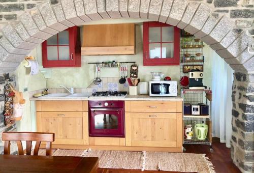 una cucina con arco, piano cottura e forno a microonde di Casa Belvedere a Moltrasio