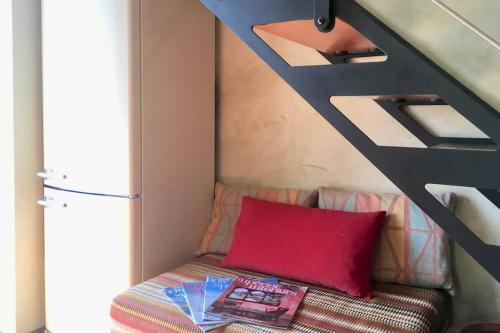 Cette chambre comprend un canapé et un oreiller rouge. dans l'établissement Casa Belvedere, à Moltrasio