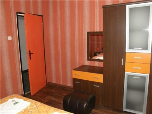 ein Badezimmer mit einem roten Schrank und einem Spiegel in der Unterkunft Apartment Bulgaria in Chissarja