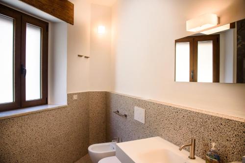 La salle de bains est pourvue d'un lavabo et d'un miroir. dans l'établissement Il Giardino Di Tatiana Rooms & Breakfast, à La Maddalena