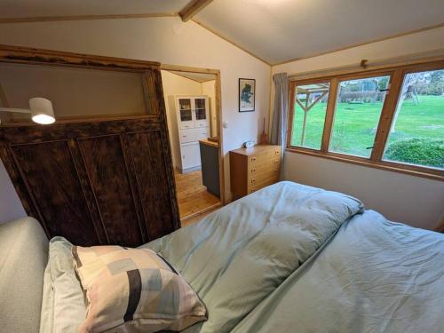 een slaapkamer met een bed en een groot raam bij The Walnut Cottage in Neustadt in Holstein