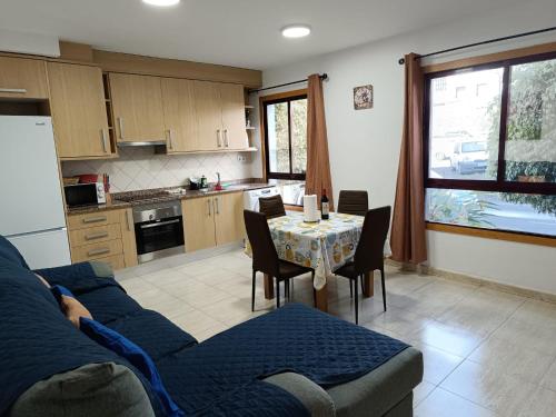 una cucina con divano blu e tavolo con sedie di paraiso soleado a Tazacorte