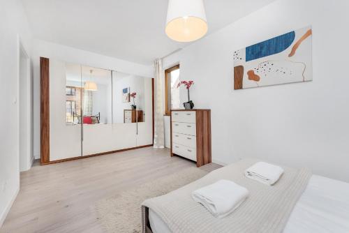 a white bedroom with a bed and a mirror at Old Town Apartment Browar Lubicz Krakow in Krakow