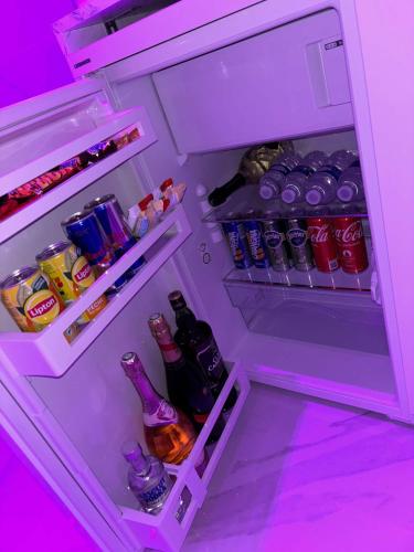- un réfrigérateur ouvert rempli de boissons et de sodas dans l'établissement Pinkroom06, à Nice