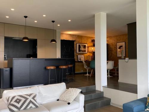 a living room with a white couch and a kitchen at Villa: Piscine, proche Centre & Mer in Saint-Jean-de-Luz