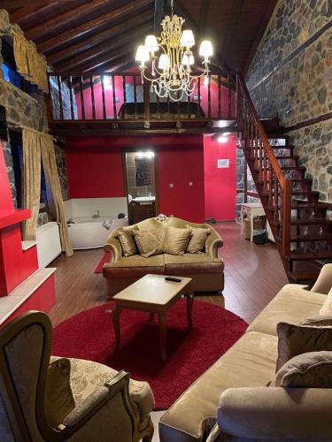 a living room with a couch and a staircase at Gioras Hotel in Palaios Agios Athanasios