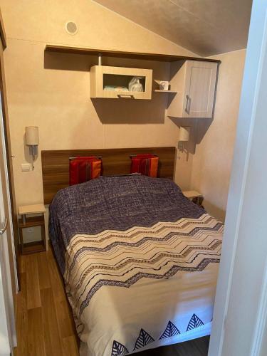 um quarto com uma cama num pequeno quarto em MOBIL HOME em Noyelles-sur-Mer