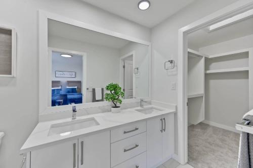 a white bathroom with two sinks and a mirror at Sunny Perch Stay in Edmonton