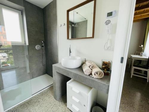 a bathroom with a sink and a shower with a mirror at La casa di Amos in Vaprio dʼAdda