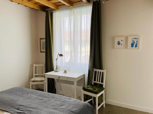 a bedroom with a bed and a desk and a window at La casa di Amos in Vaprio dʼAdda