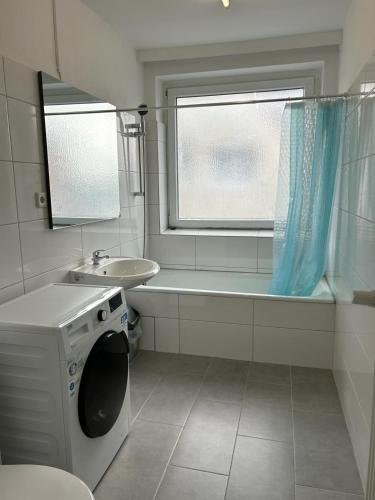 y baño con lavadora y lavamanos. en Othman Appartements Anderter Straße 55g, 1 OG L en Hannover