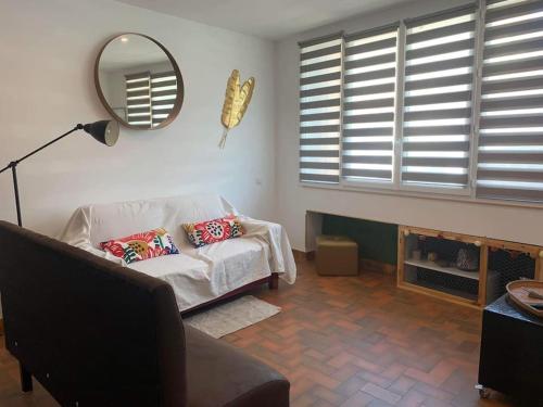 uma sala de estar com um sofá e um espelho em Maison de ville très lumineuse au centre ville em Dax