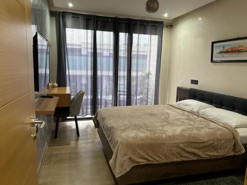 um quarto com uma cama, uma secretária e uma janela em Agadir Bay Residence - Near corniche and a lot of restaurants and stores em Agadir