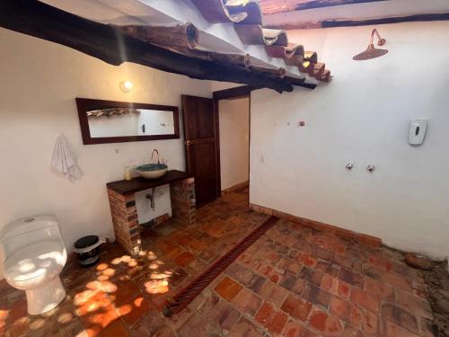 een badkamer met een toilet en een stenen vloer bij EcoHotel Barichara in Barichara