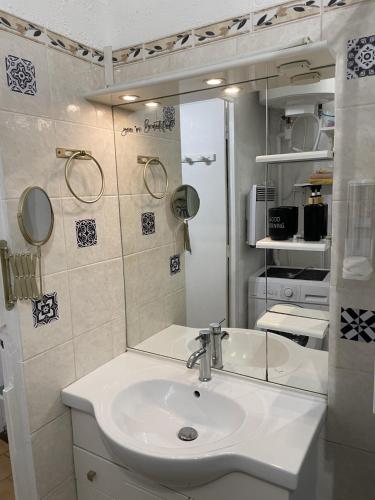 une salle de bain avec un lavabo et un miroir dans l'établissement Appartement la Marseillaise, à Marseille