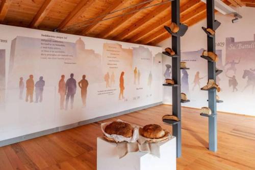 a wall with a table with a loaf of bread on it at Moderno e Confortevole Appartamento, Wi-Fi e Parcheggio Gratuito in Sanluri