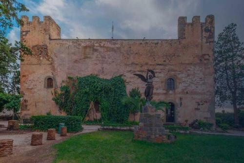 an old building with a statue of a bird on it at Moderno e Confortevole Appartamento, Wi-Fi e Parcheggio Gratuito in Sanluri