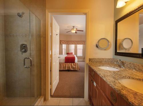 a bathroom with a sink and a shower and a bedroom at Westgate town center resort in Orlando