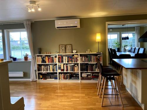 斯特倫斯塔德的住宿－Ronningen Villa，客厅设有书架,书架上摆放着书籍