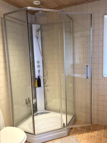 a shower with a glass door in a bathroom at Ronningen Villa in Strömstad