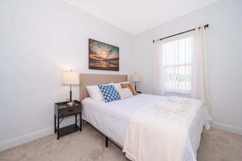 a white bedroom with a bed and a window at Home with amenities - Family vacation in Orlando in Kissimmee