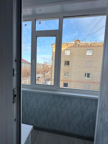 a window with a view of a building at Французский центр in Kostanay