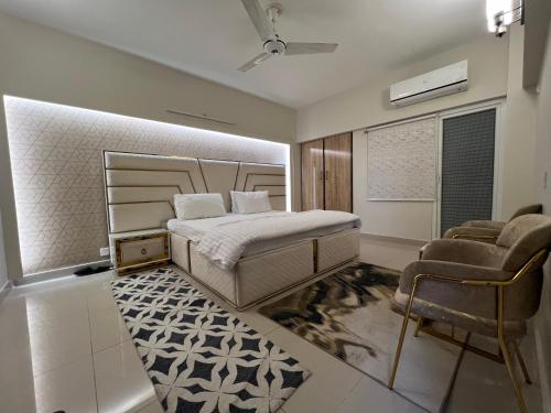 een slaapkamer met een bed en 2 stoelen. bij Comfortia Guest House 3 Bed with DringDining in Karachi