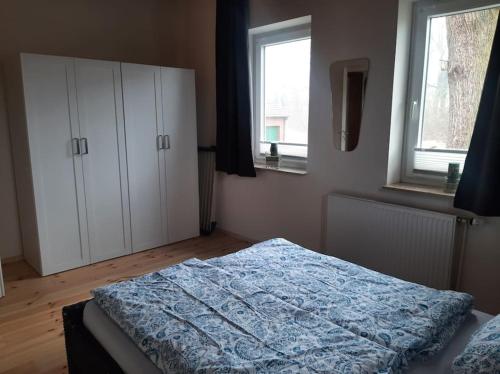 a bedroom with a bed and two windows at Ferienwohnung auf dem Land in Ladbergen