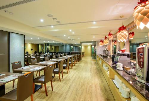 台中市にある星漾商旅ステイホテル-台中一中の長いテーブルと椅子、カウンターのあるレストラン