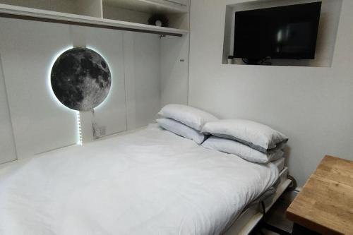 a bedroom with a bed with pillows and a television at The Nook: Self Contained Annex in Taunton