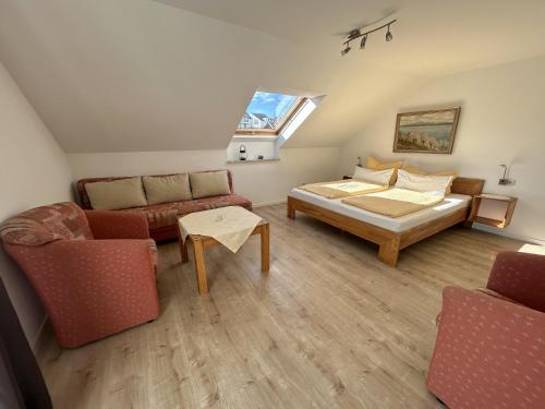 a bedroom with a bed and a couch and a window at Gästehaus Sommertal in Meersburg