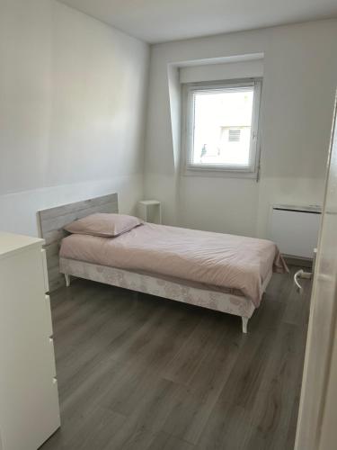 une petite chambre avec un lit et une fenêtre dans l'établissement Entre Paris et Disneyland, à Chelles