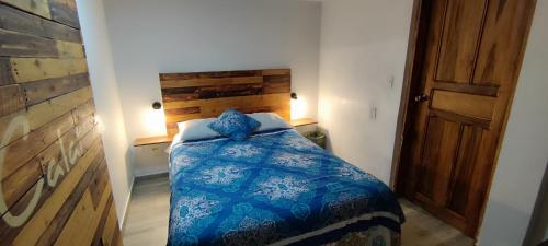 a bedroom with a bed with a blue comforter at Minka Hostel in Quito
