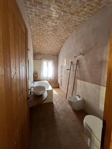 une salle de bain avec deux lavabos et une baignoire et des toilettes dans l'établissement MAISON DE CARACTERE A PIGNA, à Pigna