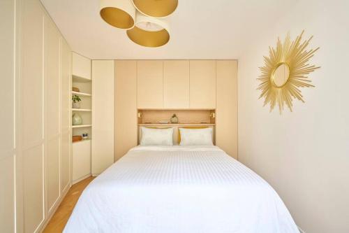 パリにあるElegant central flat in Paris, near Saint Germainの白いベッドと天井ファンのある寝室